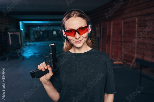 Confident female shooter in safety goggles looking ahead photo