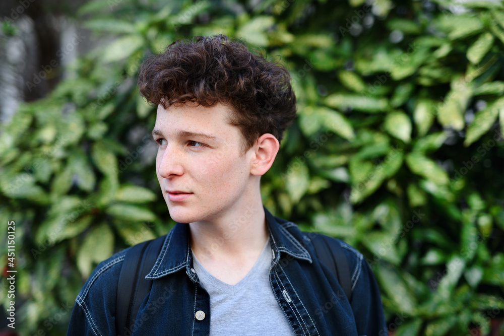Close-up portrait of young man against green background outdoors. Close-up portrait of young man against green background outdoors.