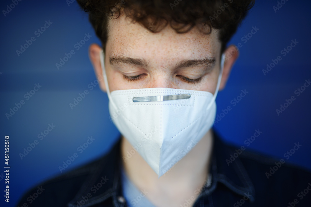 Headshot portrait of young man with respirator against green background outdoors, coronavirus concept. Headshot portrait of young man with respirator against green background outdoors, coronavirus concept.