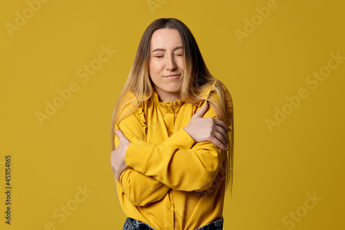 blonde woman hugging oneself happy and positive © producer