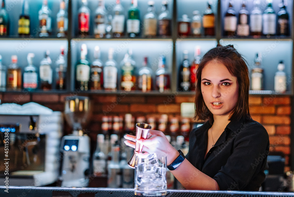 Portrait of young attractive woman bartender Making Cocktail in bar
