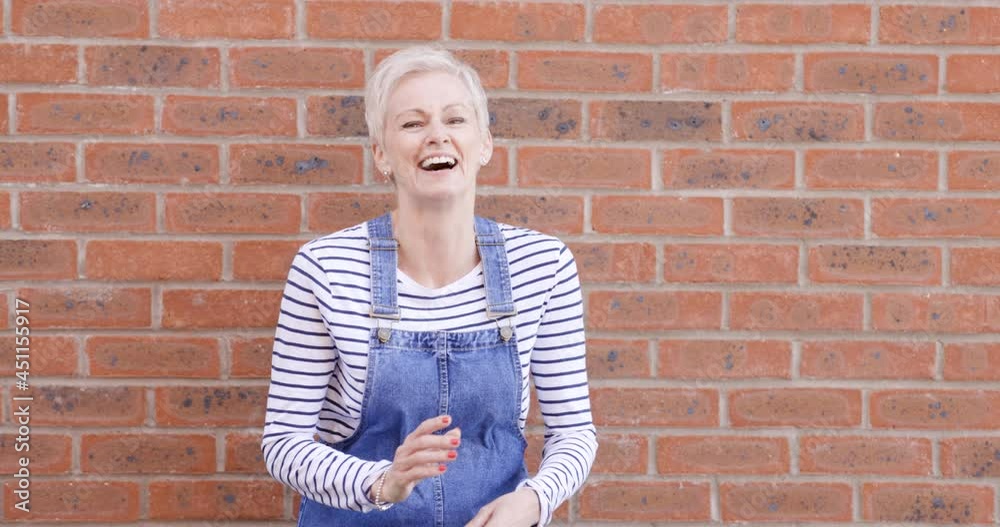 Woman with arms crossed standing in front of brick wall Woman with arms crossed standing in front of brick wall