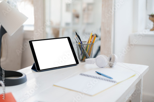 White working table with blank screen digital tablet