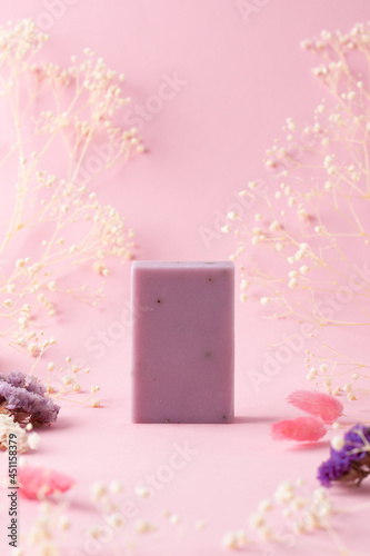 Soap with flowers on pink background. Close up, copy space.
