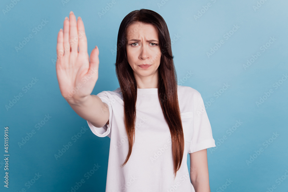 Young brunette woman isolated over blue background doing stop sign with palm hand Young brunette woman isolated over blue background doing stop sign with palm hand