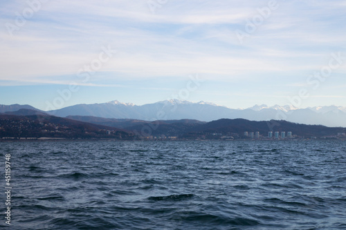 sunrise in the sea. pink haze of the rising sun over the sea. City and mountains on the horizon. Sochi, Russia, city view from the sea