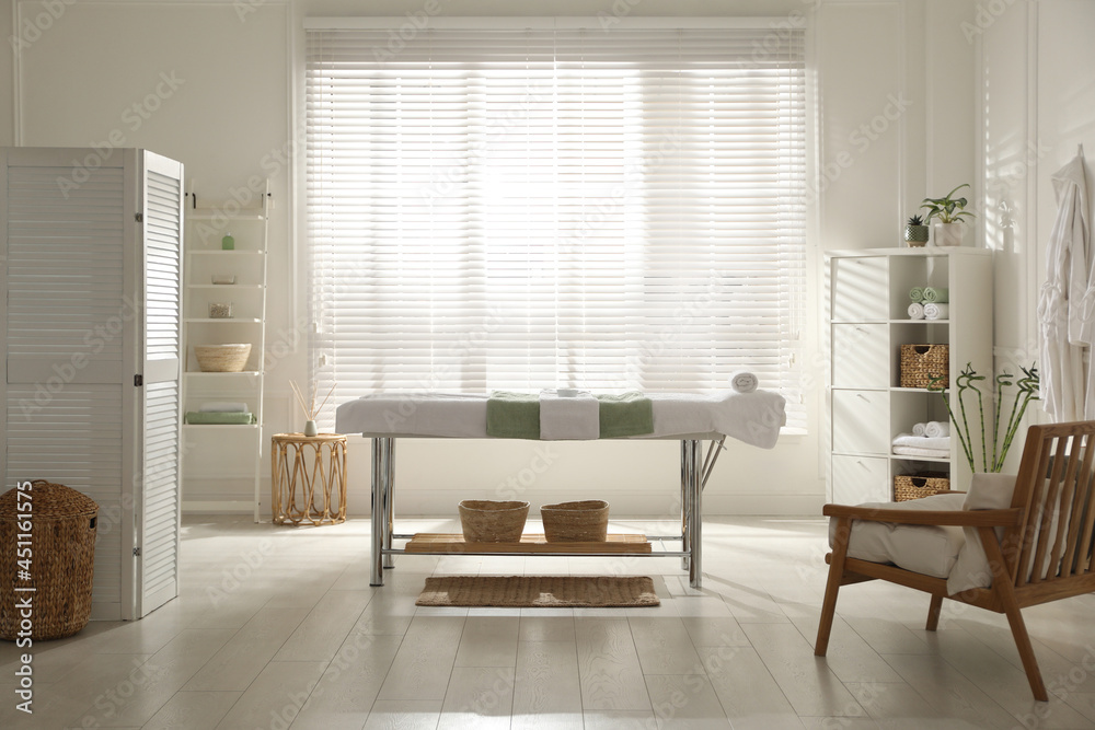 Fototapeta premium Stylish spa salon interior with massage table