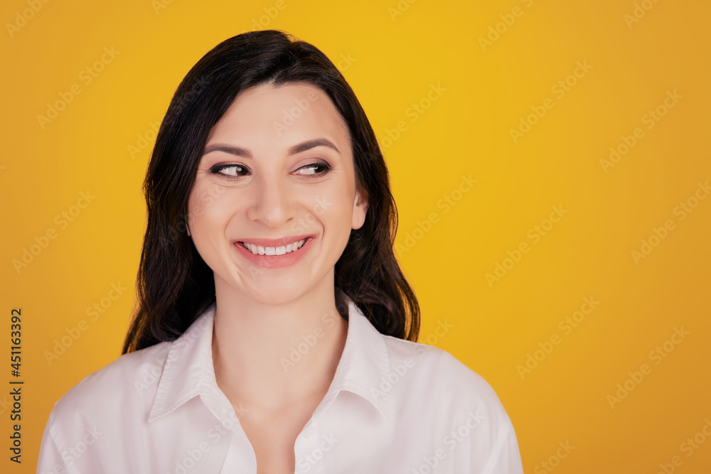 Portrait of charming cheerful girl white smile look side empty space on yellow background Portrait of charming cheerful girl white smile look side empty space on yellow background