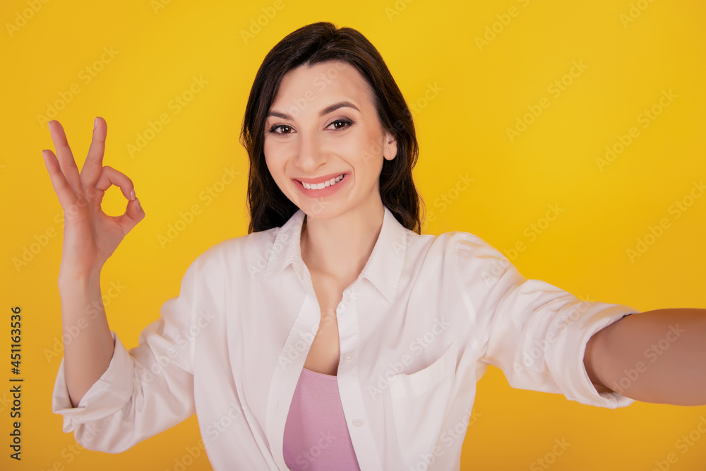 Portrait of advertisement concept positive girl make selfie show okey on yellow background Portrait of advertisement concept positive girl make selfie show okey on yellow background
