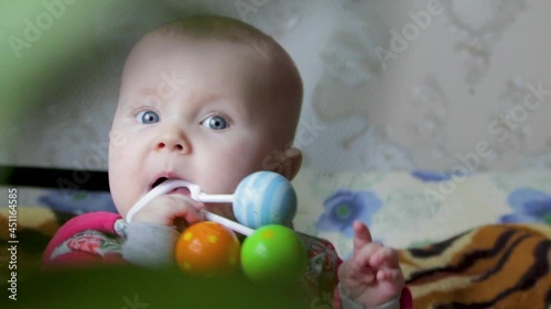 the baby gnaws the toy with the first teeth,the baby bites the toy, the baby's first teeth, the baby's gums itch photo