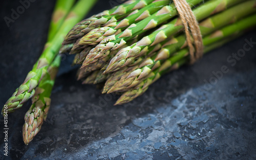 Asparagus. Fresh raw organic green Asparagus sprouts closeup. On black slate table background. Healthy vegetarian food. Raw vegetables, market. Healthy eating concept, diet, dieting