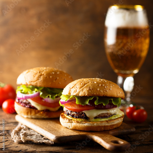 Traditional homemade cheeseburgers with lettuce and onion