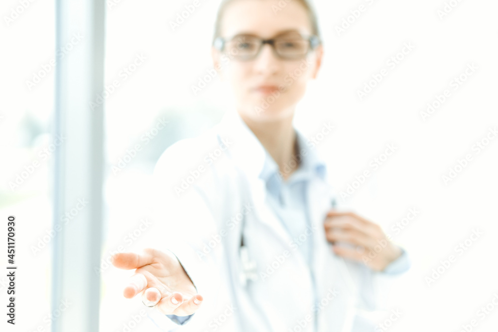 Beautiful woman doctor with stethoscope smiling charmingly and ready to help patients in the modern hospital. Medicine concept
