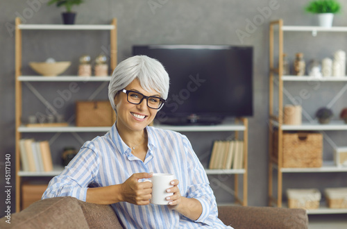 Foto Cheerful adult lady spending time at home and enjoying good cuppa tea