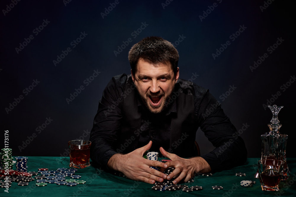 Bearded casino player man playing poker on green table Bearded casino player man playing poker on green table