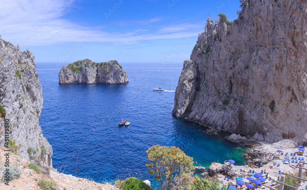 Rocky beach near Faraglioni (sea stacks) of Capri in Italy.