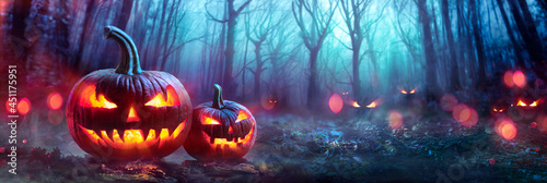 Halloween Pumpkins In A Spooky Forest At Night With Evil Eyes