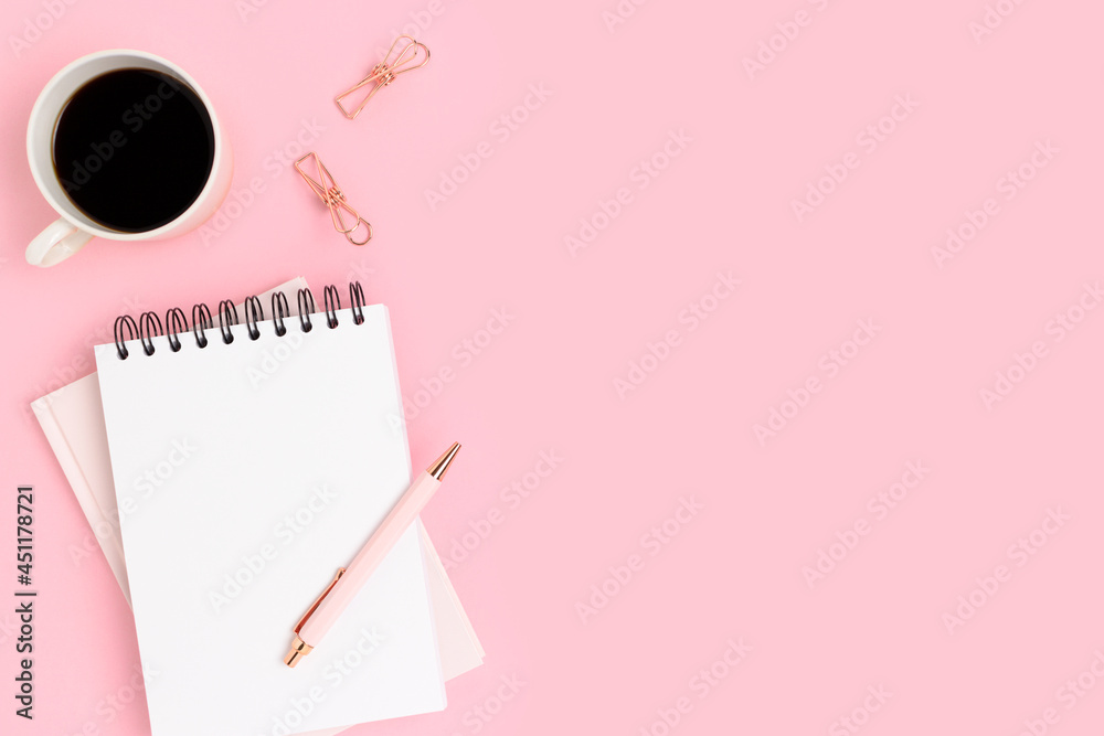 Workspace with blank notepad mockup, stationery and coffee cup on a pink background. Education concept with copyspace. Workspace with blank notepad mockup, stationery and coffee cup on a pink background. Education concept with copyspace.