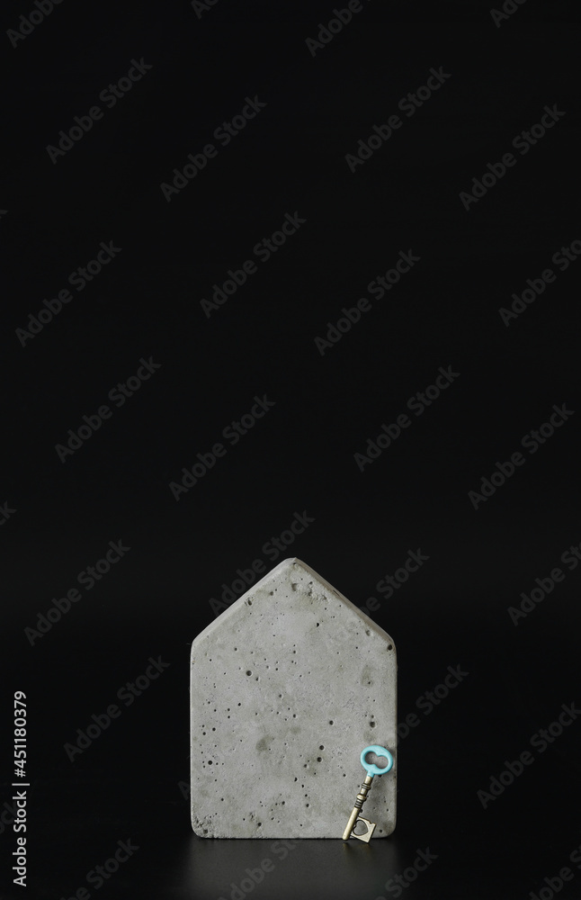 Mini concrete house model and a key on the black background. Buy a house. Concept for property ladder, mortgage and real estate investment. Free space for text, copy space, modern layout. Mini concrete house model and a key on the black background. Buy a house. Concept for property ladder, mortgage and real estate investment. Free space for text, copy space, modern layout.