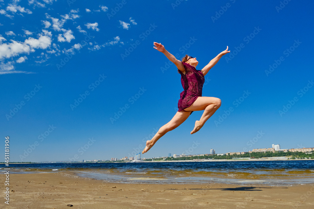 Striving for high goals through overcoming yourself. Jumping on the beach in the water.