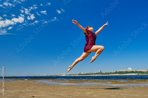 Striving for high goals through overcoming yourself. Jumping on the beach in the water.