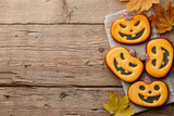 Halloween gingerbread cookies and autumn leaves on planks