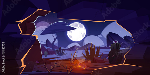 Cave with bonfire and night desert landscape.