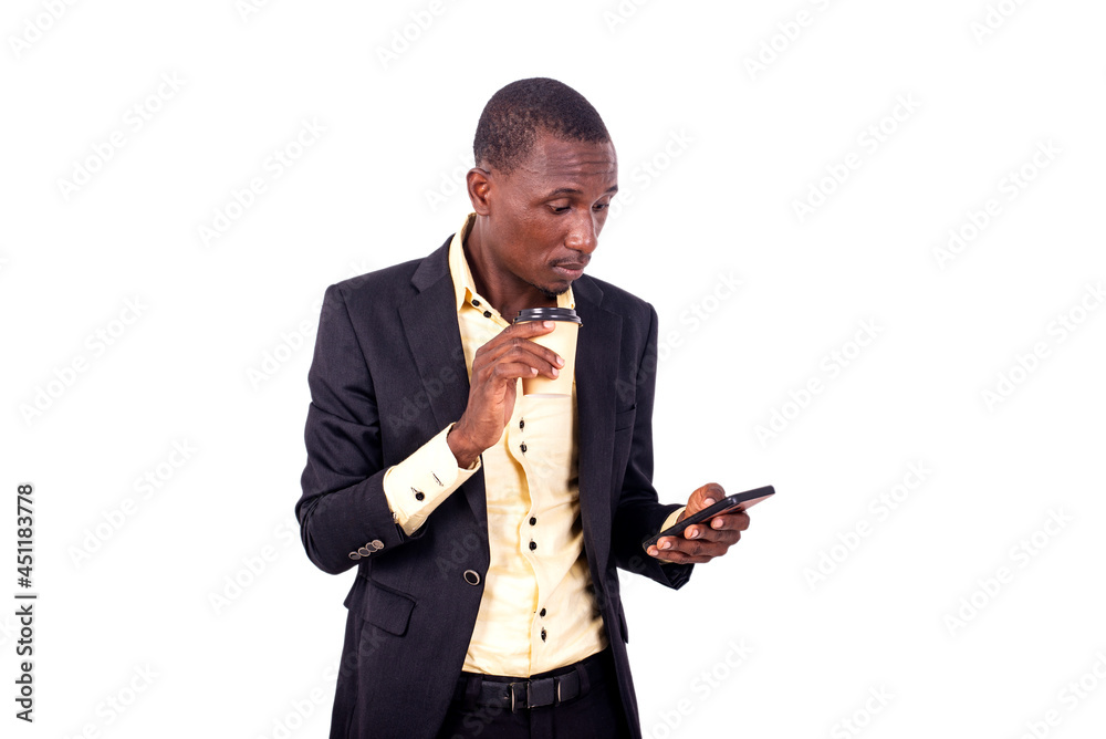 young serious businessman using a mobile phone drinking coffee. young serious businessman using a mobile phone drinking coffee.