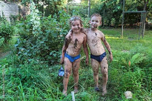 Two boys posing soiled in mud