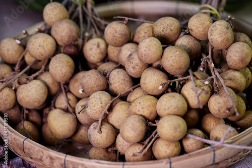 closeup bunch of ripe longan fruit on bamboo basket