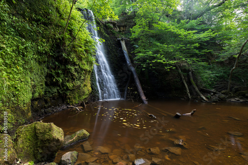 Fototapeta Naklejka Na Ścianę i Meble -  Large cascading waterfall tumbling into a peaceful pool near whitby. Falling foss waterfall, Yorkshire Dales 