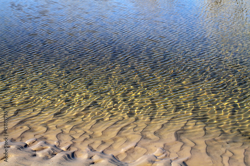 The sandy coast flows smoothly into the water