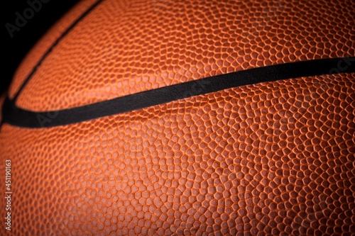 Orange classic basketball with texture on dark background © BillionPhotos.com