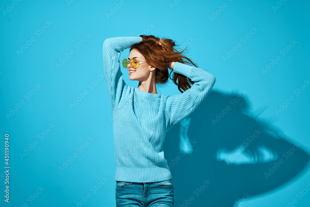 Naklejka premium pretty woman in a blue sweater blue background Lifestyle