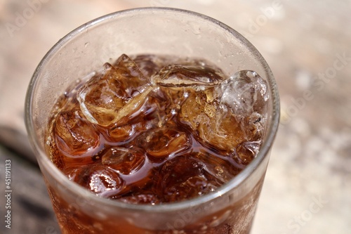 Close up of cola drink and glass on wood table background