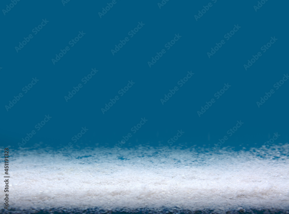 White snow isolated on blue Christmas background.