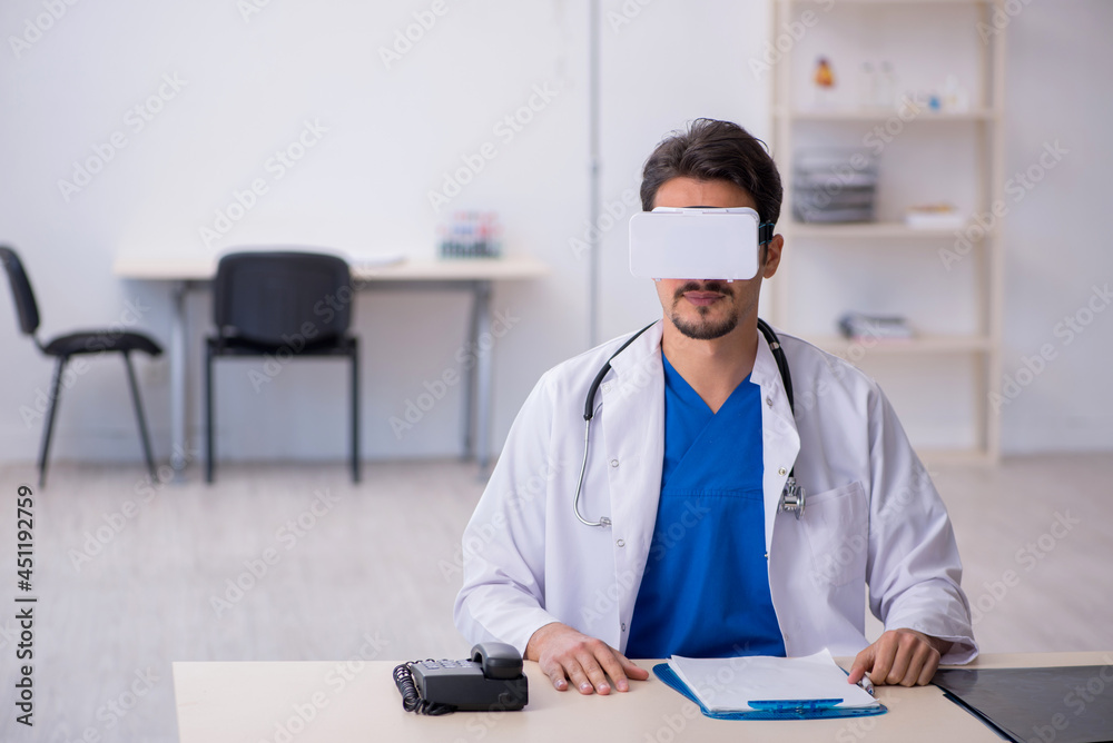 Young male doctor wearing virtual glasses in the clinic Young male doctor wearing virtual glasses in the clinic