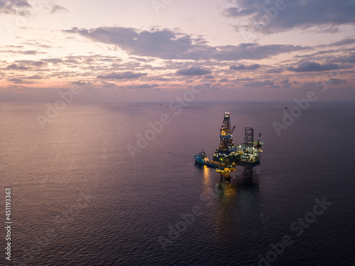 Offshore Jack Up Rig in The Middle of The Sea at Sunset Time for Petroluem Exploration and Production © bomboman