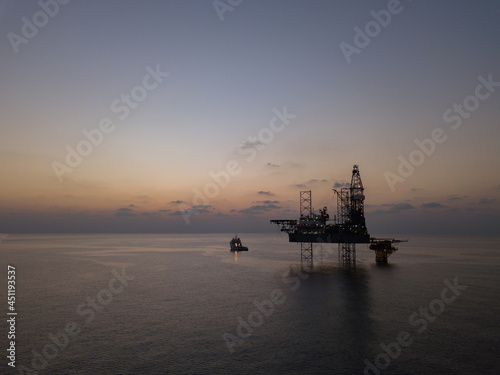 Aerial view offshore drilling rig (jack up rig) at the offshore location during sunrise