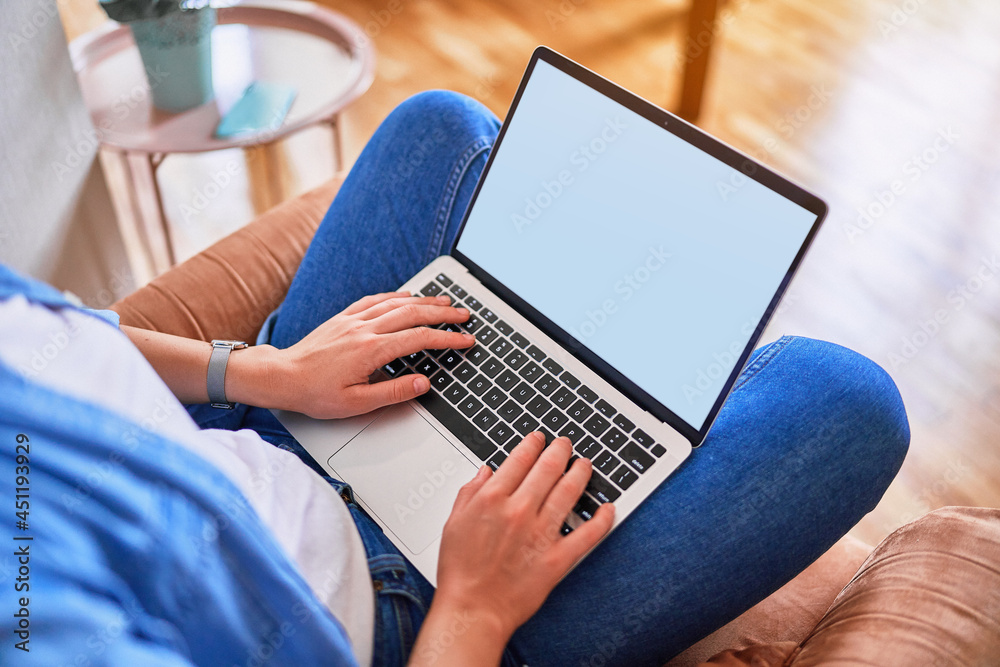 Fototapeta premium Computer screen blank mockup. Female hands typing on keyboard laptop with white background for advertising. Copy space