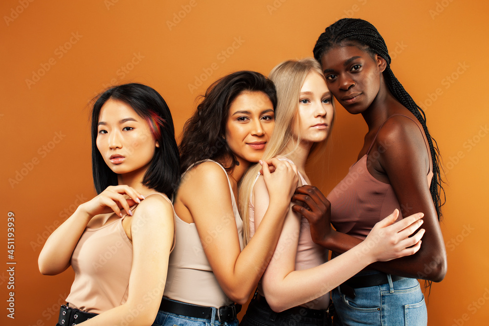 Obraz premium young pretty caucasian, afro, scandinavian woman posing cheerful together on brown background, lifestyle diverse nationality people concept
