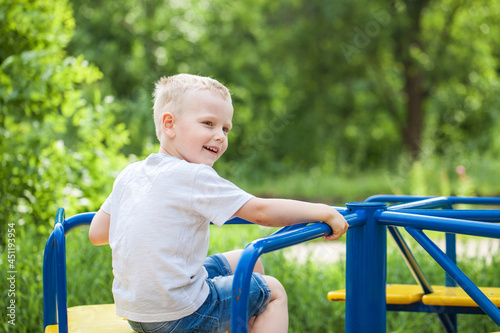 Blonde little boy in a summer park