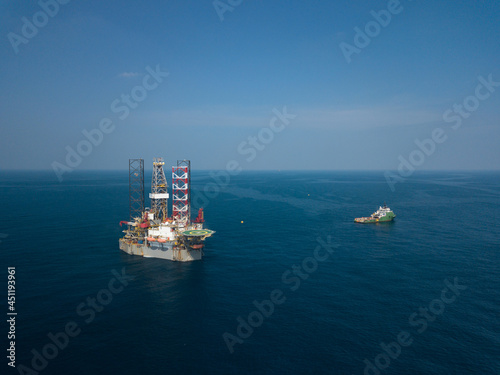 Offshore drilling rig (jack up rig) and tow vessels during the rig move operation in the middle of the ocean