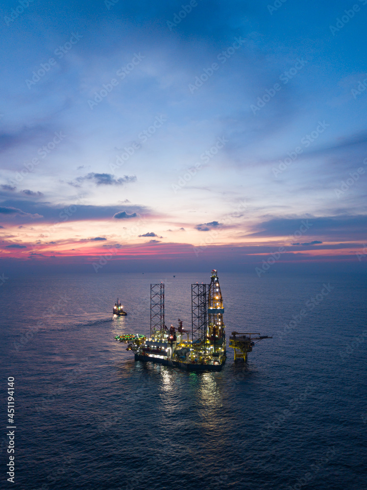 Offshore Jack Up Rig in The Middle of The Sea at Sunset Time for Petroluem Exploration and Production Offshore Jack Up Rig in The Middle of The Sea at Sunset Time for Petroluem Exploration and Production