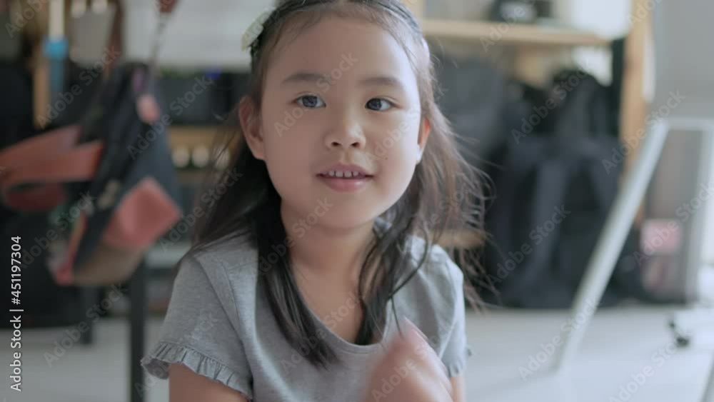 Asian girl sitting on the floor playing rock paper scissors. The camera angle focuses on the child's face. Hand-held 4k slow-motion footage Asian girl sitting on the floor playing rock paper scissors. The camera angle focuses on the child's face. Hand-held 4k slow-motion footage