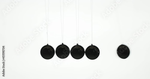 Fingers release one of the balls in Newton's pendulum - a demonstration of the law of energy conservation