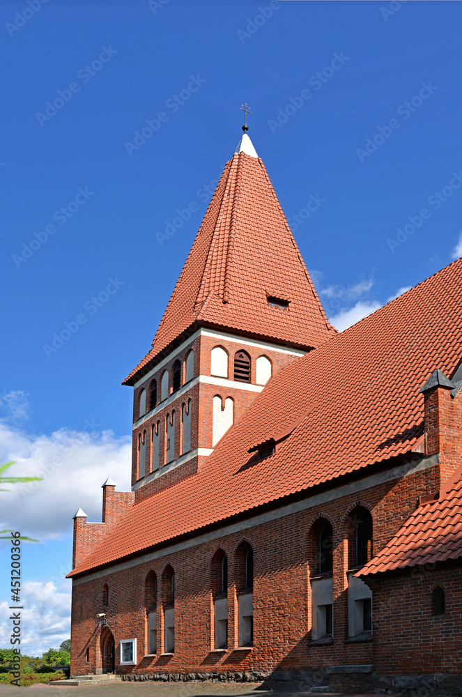 Obraz premium General view and architectural details of the Catholic Church of Our Lady Queen of Poland, built in 1894 in the Gothic style, in Pisanica in Masuria, Poland.