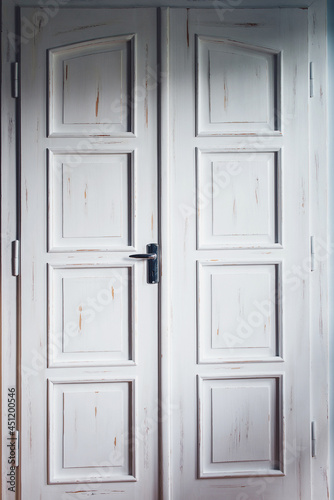 Vintage white double doors inside house. Classic wooden door.