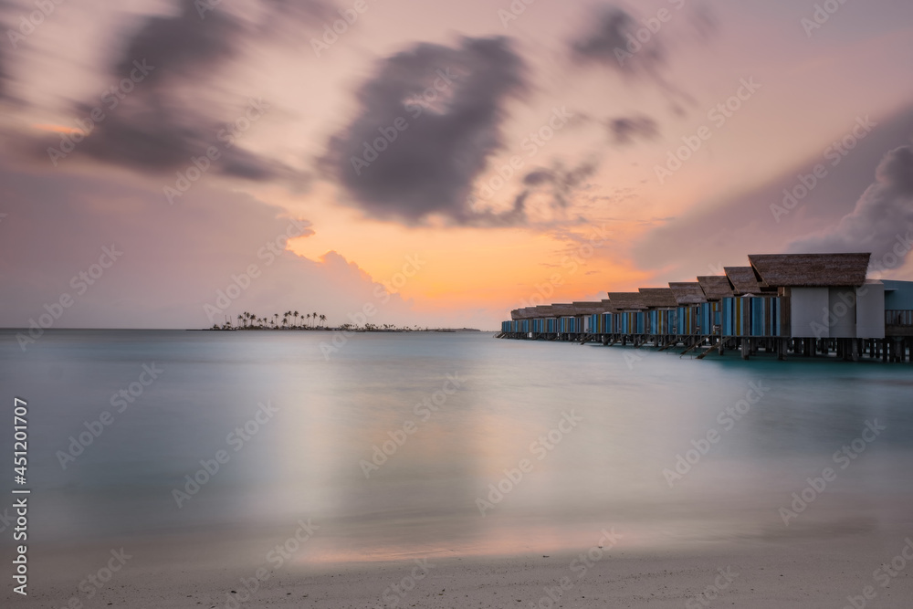 Beautiful vivid sunrise over beach with the villas in the Indian ocean, Maldives. Crossroads Maldives, hard rock hotel, july 2021
