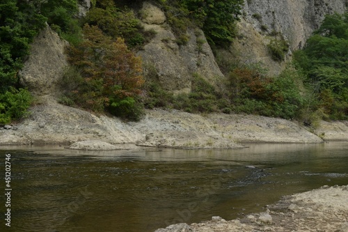 The beautiful rock mountain with the early autumn colored trees along with the Toyohira river in Sapporo Japan